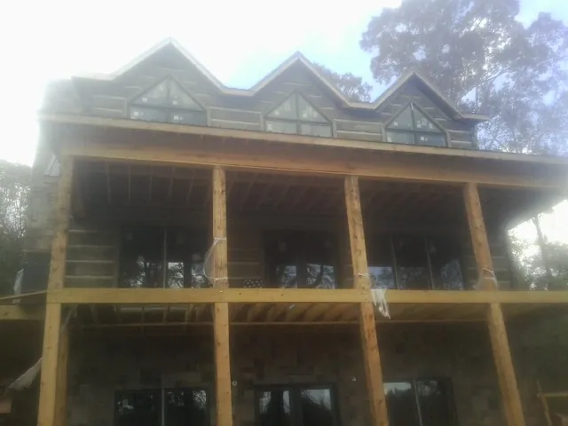 Dormers and porch framing on a large log home under construction — Roof Coating work by our crew in Draper