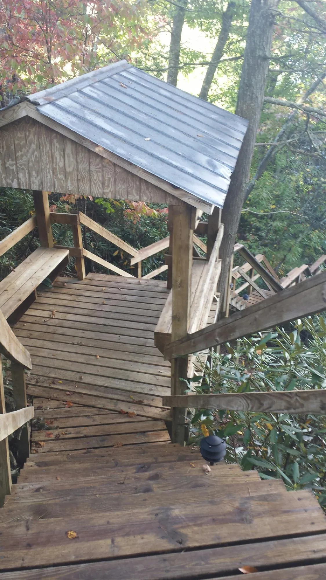 Metal roofed shelter over wooden steps on a wooded walkway — Skylight Repair & Installation work by our crew in Draper